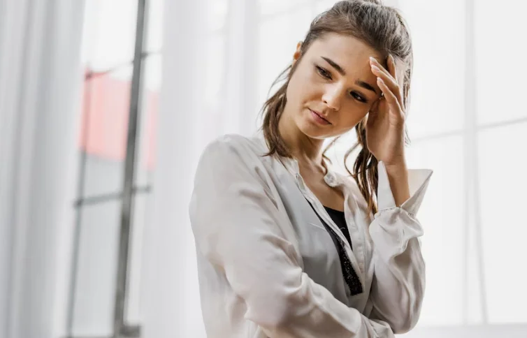 девушка с низкой самооценкой держится за голову